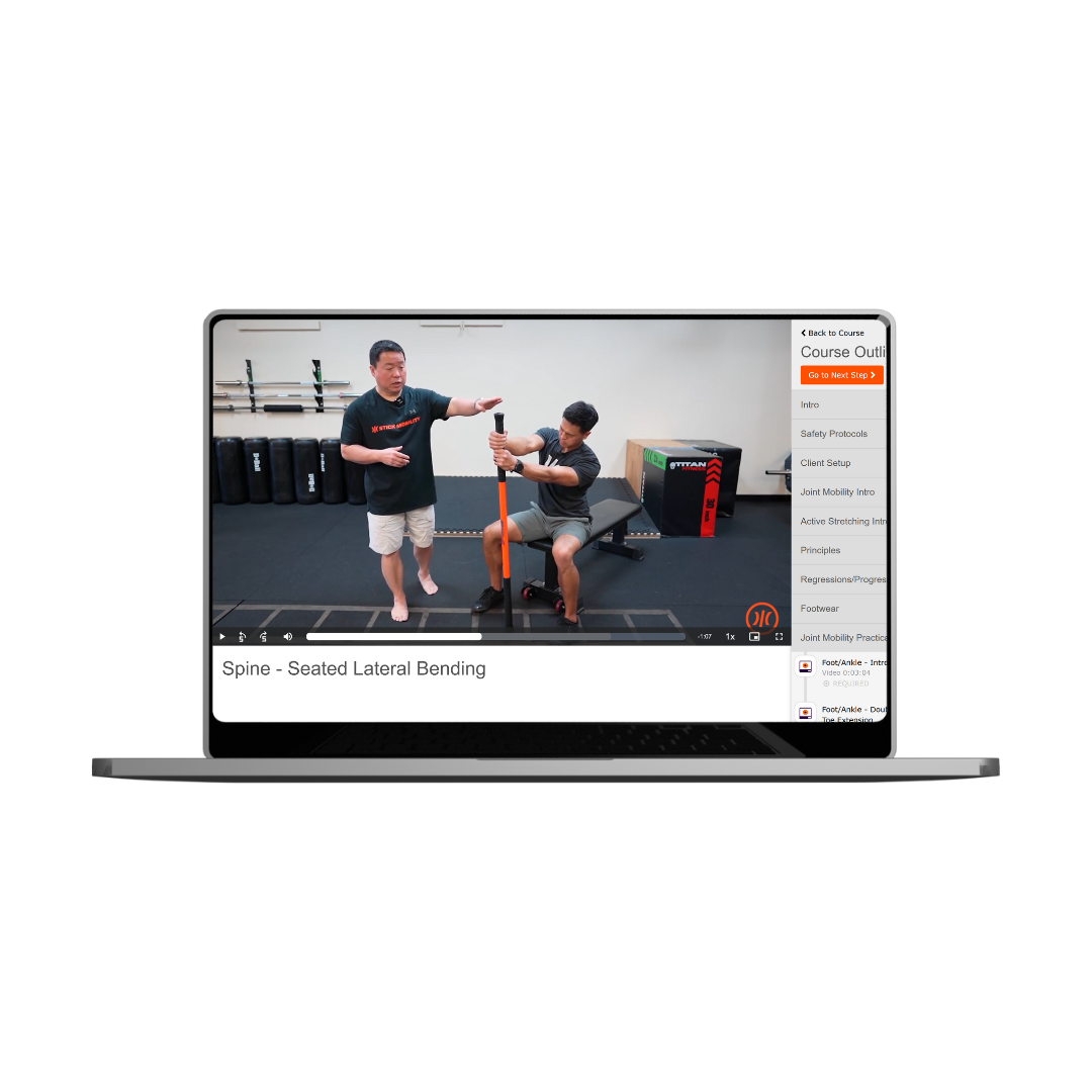 Laptop image with an video paused. The clip is from a section of the Essentials Course showing Neal and Dennis demonstrating seated lateral bending.