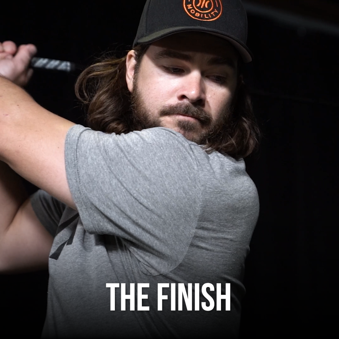 Man swinging a golf club showing the finish