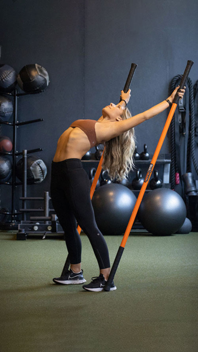 Woman stretching with Stick Mobility Training Sticks