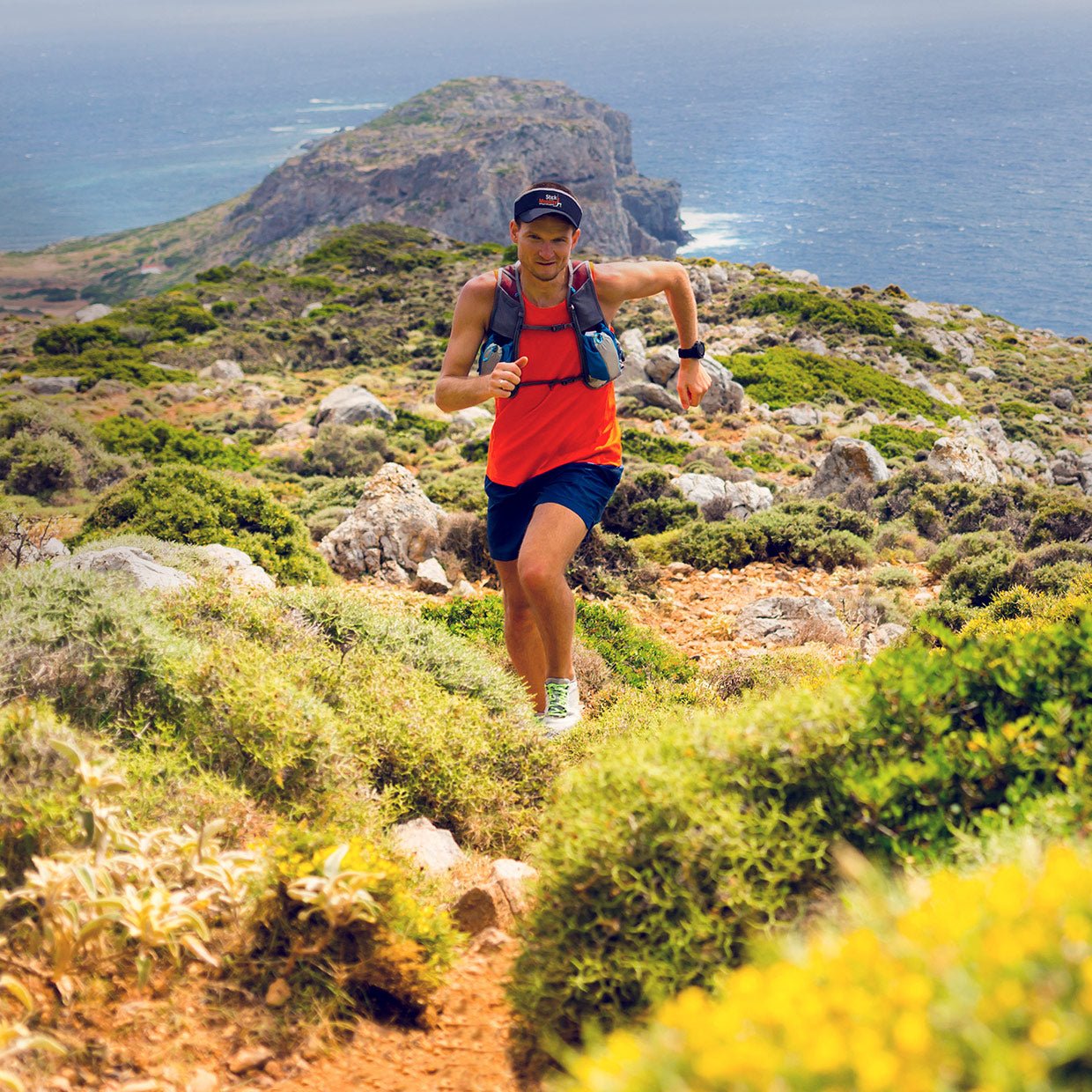 A man running with the ocean in the background.