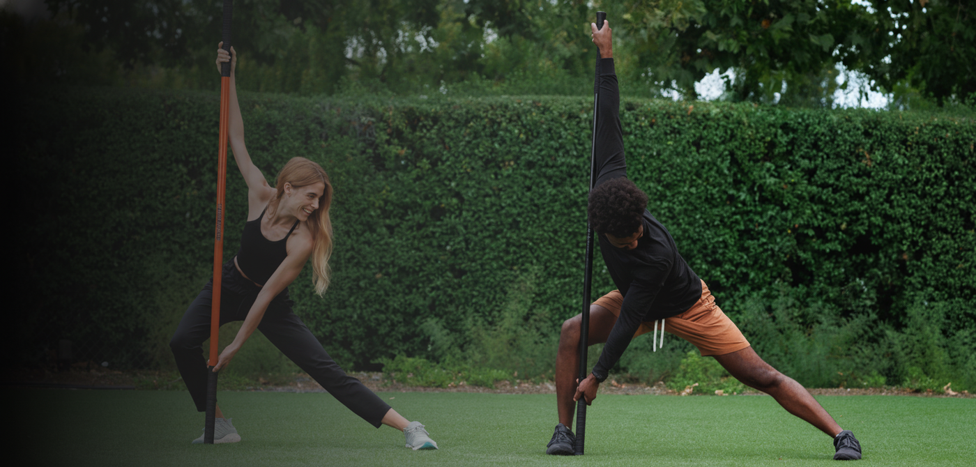 Man and woman using training sticks to stretch