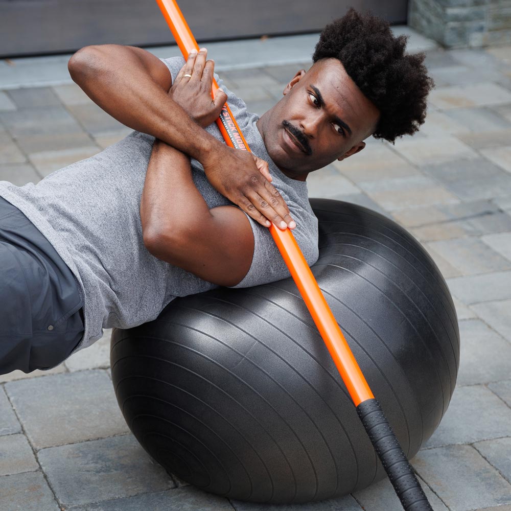 Man exercising with Training Stick and Exercise Ball
