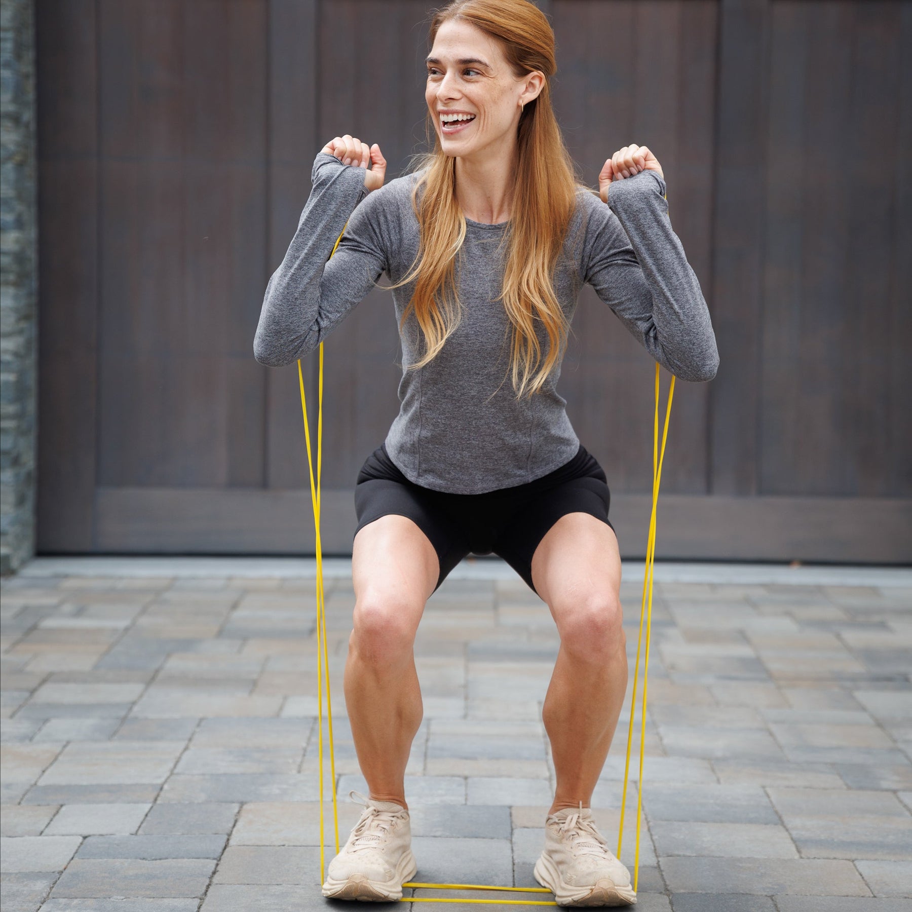 A female athlete performing strength and mobility exercises using resistance bands, showcasing dynamic movement and muscle activation.