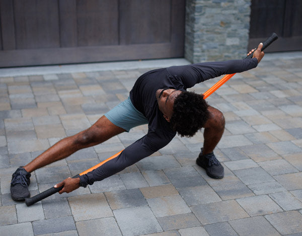 Man displaying flexibility with Stick Mobility training stick