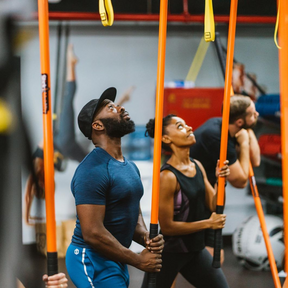 A man and a woman pushing their Training Stick into the ceiling.