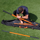 The Stick Mobility training stick carry bag placed on the ground outdoors, showcasing its durable design and functionality for mobility training storage and transport.