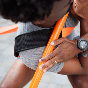 Man showing the stick mobility torsion strap while holding a training stick.