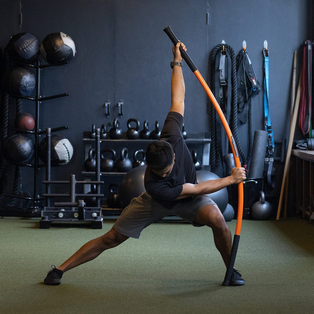 Man performing the lateral bow and arrow with the Training Stick.